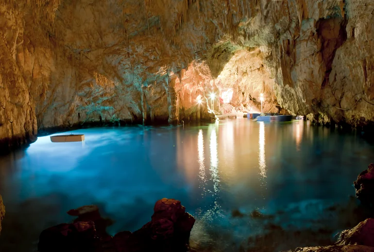 Sea cave on the Italian Mediterranean coast with sunlit emerald water inside