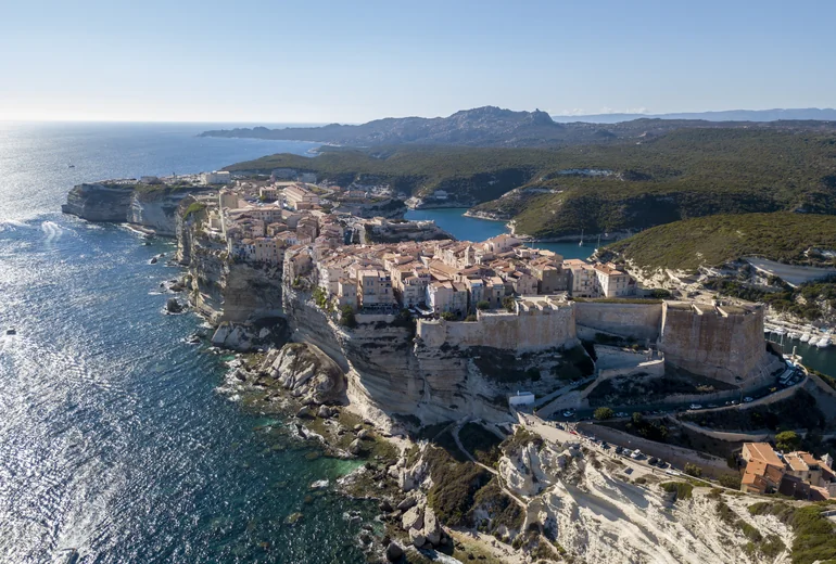 Bonifacio harbour seen from the sea with limestone cliffs